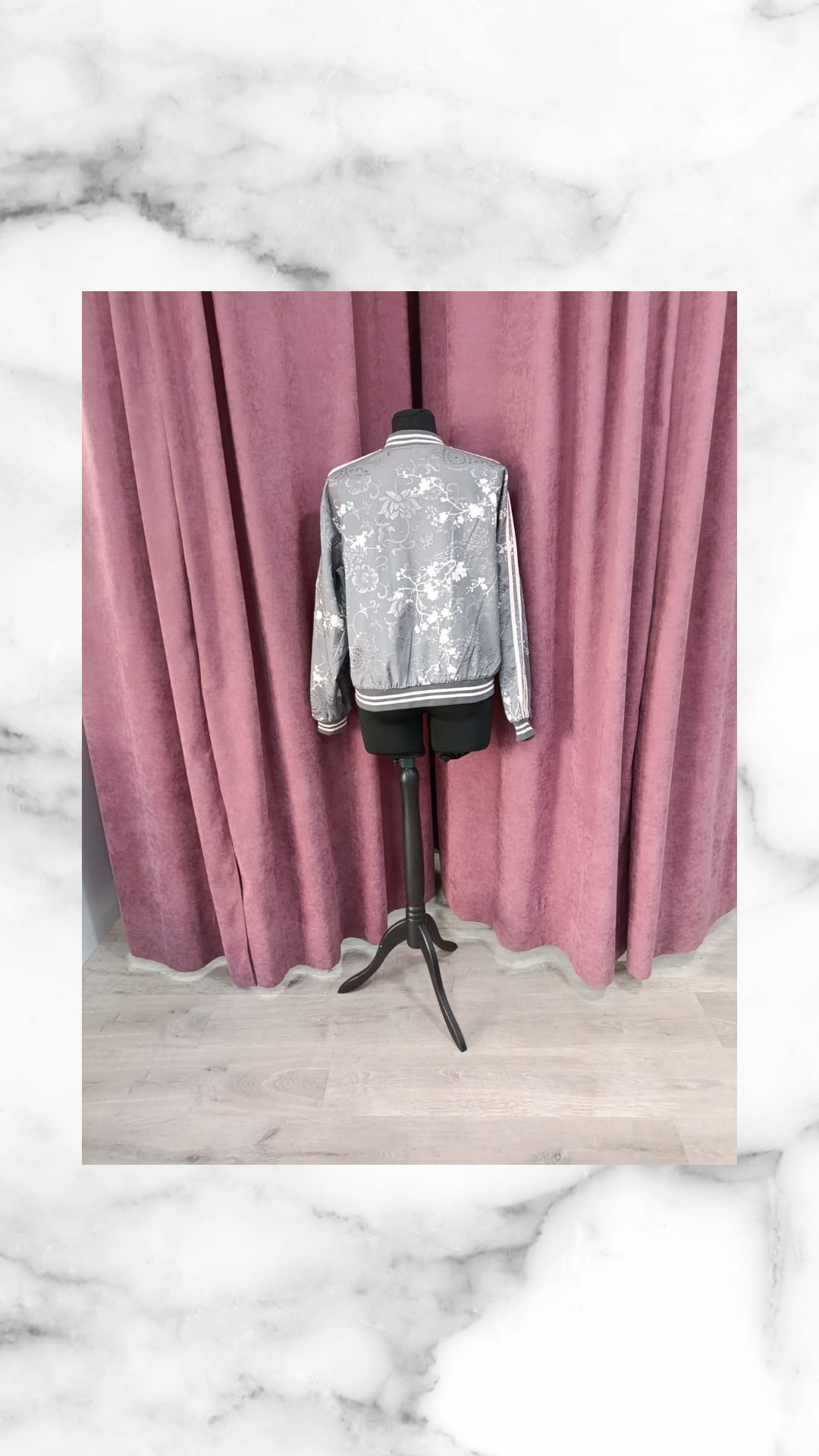 Chaqueta bomber Asia gris de lentejuelas plateadas en un maniquí negro