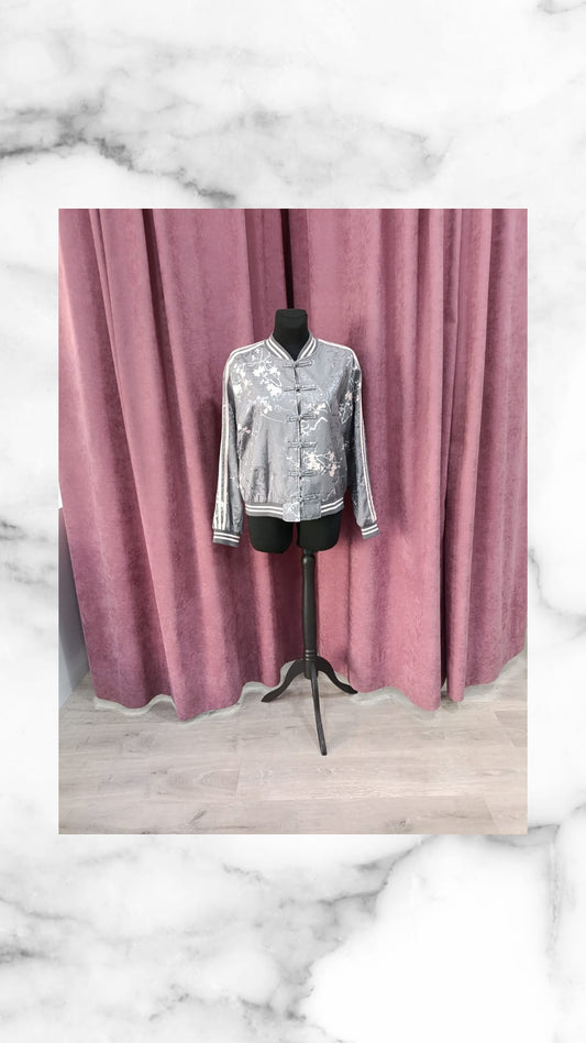 Chaqueta bomber ASIA gris de lentejuelas plateadas en maniquí negro
